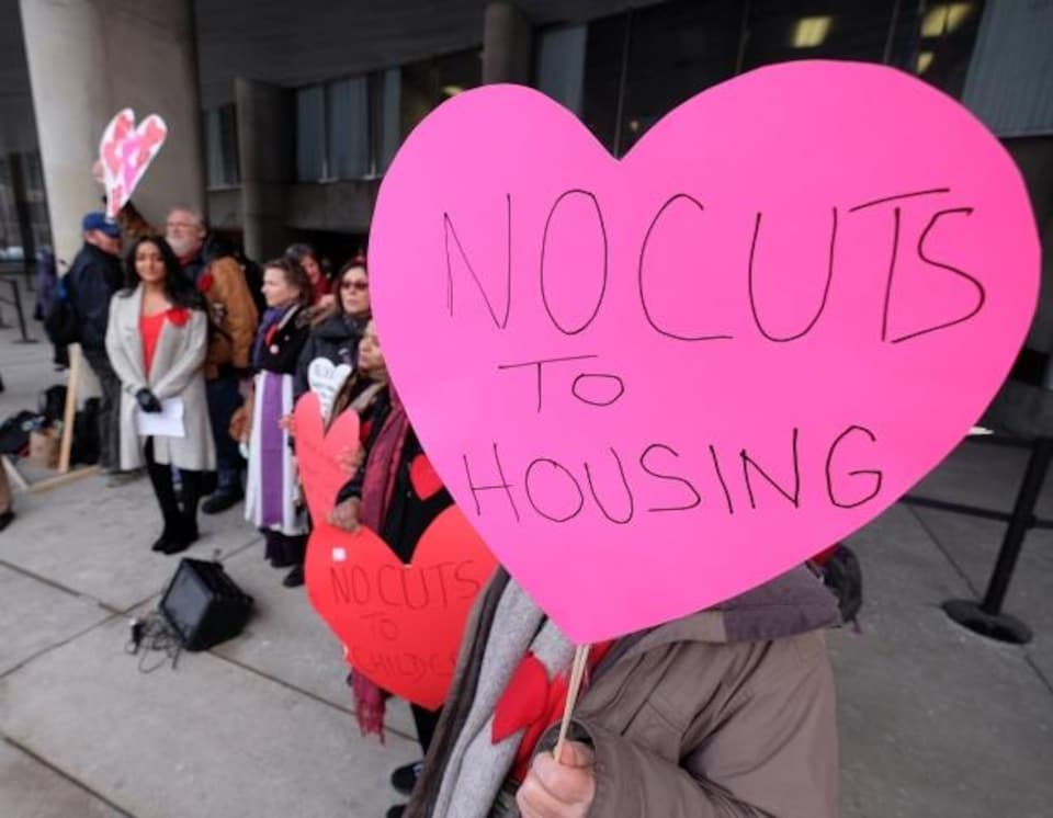 Photo d'une affiche à une manifestation contre les coupes dans le budget à l'aide au logement.