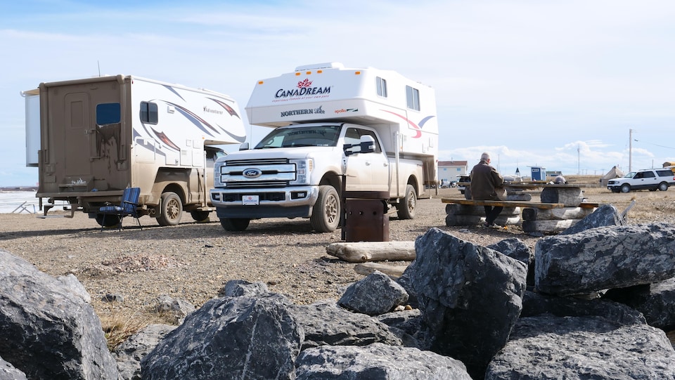 Deux caravanes et un touriste dans un endroit aménagé pour des pique-niques à Tuktoyaktuk.