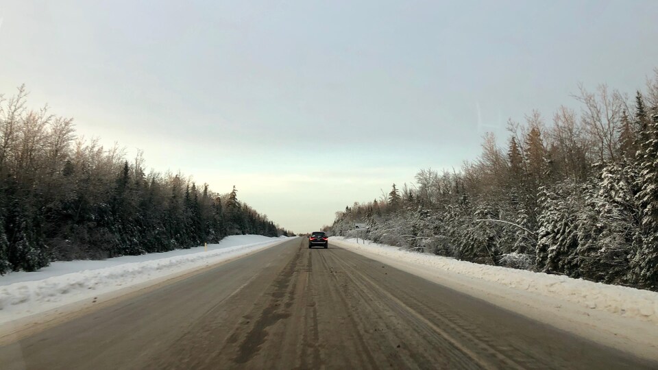 Une voiture progresse sur la route glacée