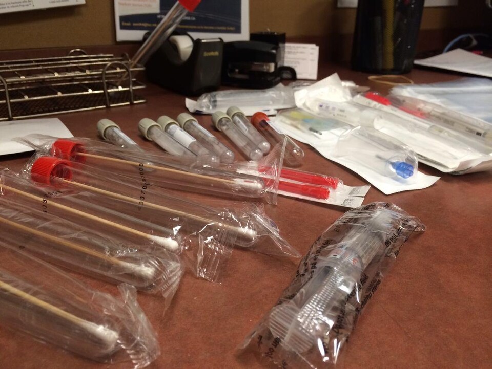 Des échantillons, des seringues et du matériel médical disposés sur une table. 