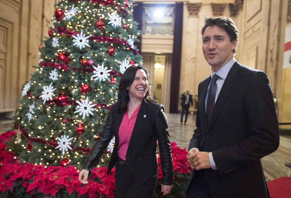 Valérie Plante et Justin Trudeau devant un sapin de Noël dans le hall de l'hôtel de ville de Montréal.