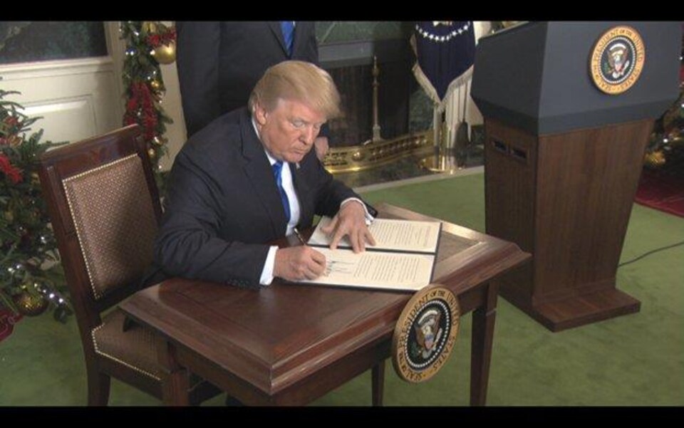 Donald Trump signe un texte.
