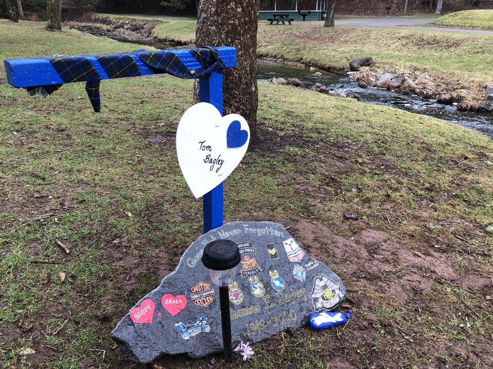 Un coeur au nom de Tom Bagley et une roche sur laquelle sont dessinés plusieurs insignes, dont un des Forces armées, et des motocyclettes.