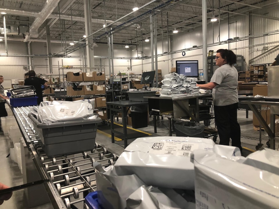 Des employés s'activent dans un entrepôt.