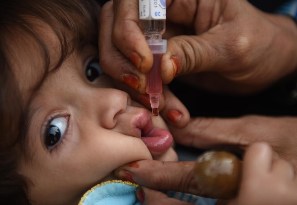 Gros plan sur le visage d'une fillette qui reçoit un vaccin par voie orale.