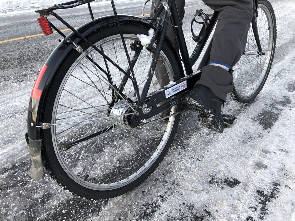 Un vélo sur une route enneigée et glacée.