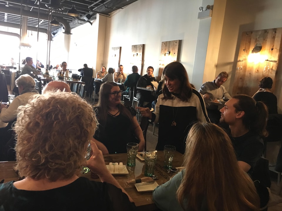 Véronique Hivon discute avec des gens assis à une table au bistro Café Summum.