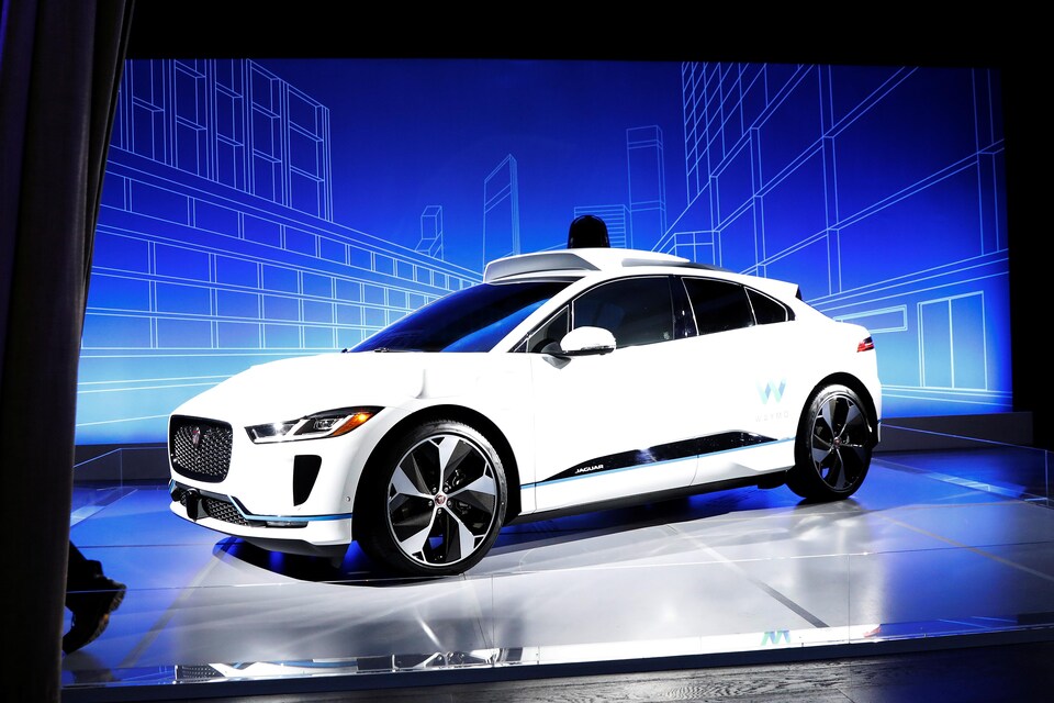 Une photo montrant une voiture blanche de marque Jaguar. De l'équipement est installé sur son toit.
