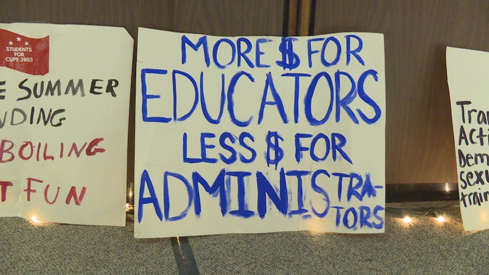 Photo d'une affiche qui réclame en lettres bleues plus d'argent pour les éducateurs plutôt que l'administration.