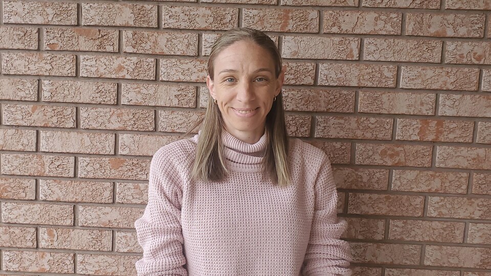 He was standing in front of a brick wall.