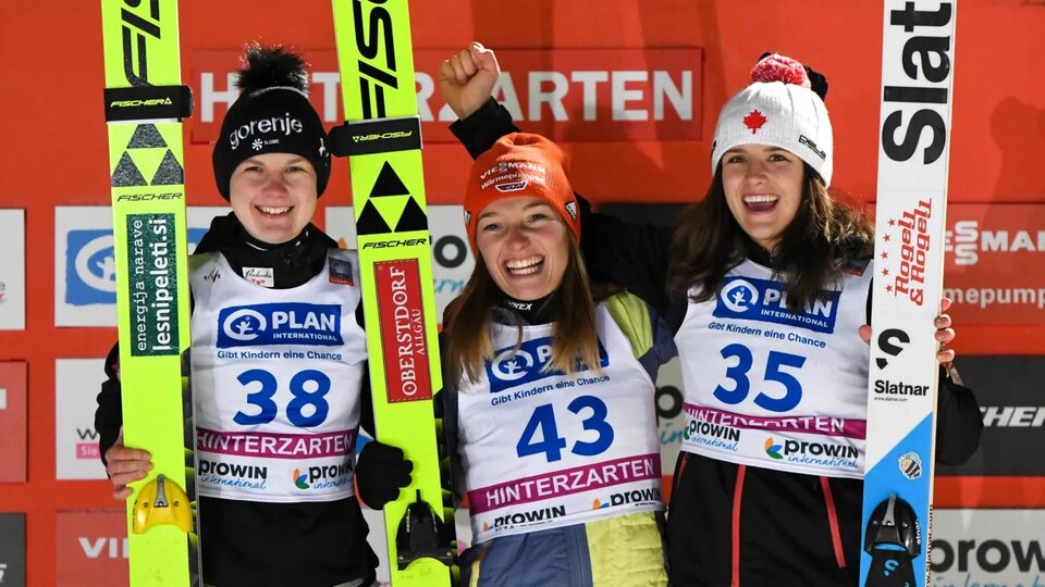 Les trois meilleures skieuses de la Coupe du monde de Hinterzarten célèbrent leur performance, leurs skis dans les mains. 