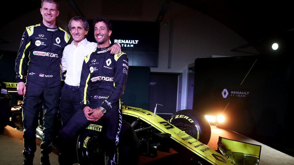 Trois personnes souriantes devant une monoplace 