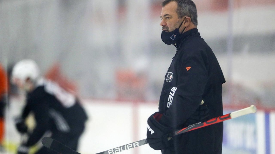 Philadelphia Flyers head coach Alain Vigneault watches his players during NHL hockey practice, Monday, Jan. 4, 2021, in Voorhees, N.J. (Yong Kim/The Philadelphia Inquirer via AP)