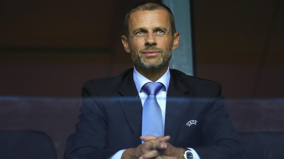 Un homme en complet se croise les mains.