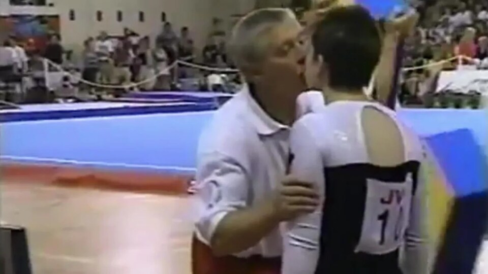Alex Bard embrasse une jeune athlète sur la bouche.