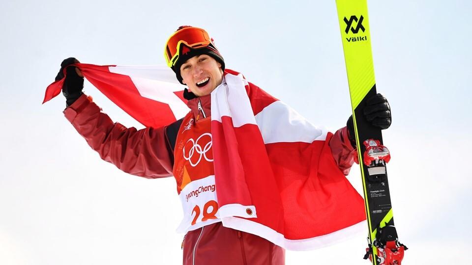 Il célèbre avec un drapeau du Canada sur les épaules.
