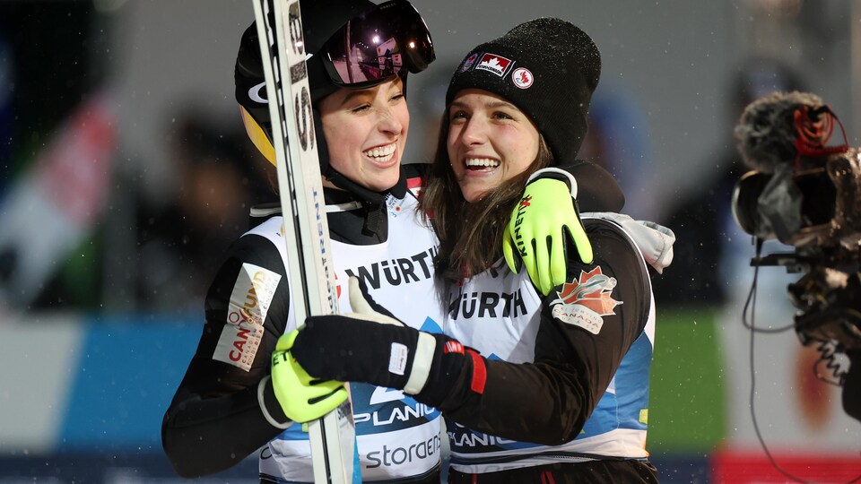 Alexandria Lotet and Abigail Strat embrace to celebrate Alexandria's win in ski jumping.