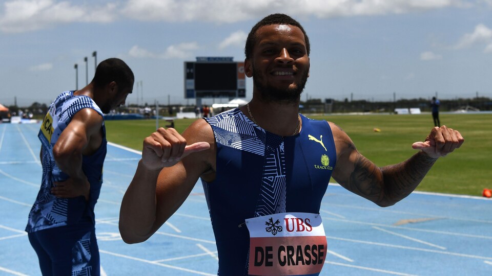 Andre De Grasse pointe ses pouces vers lui-même.