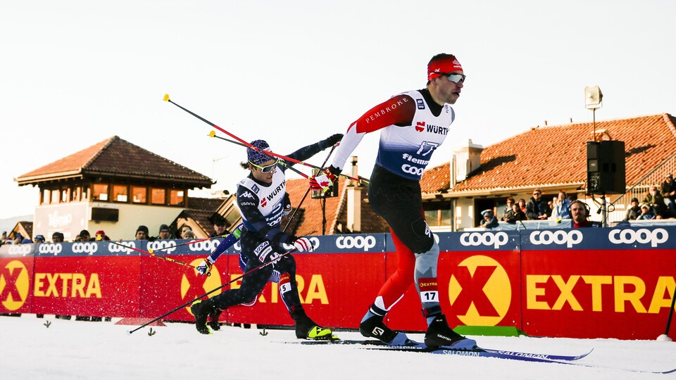 Deux skieurs traversent le fil d'arrivée à la fin d'une course.
