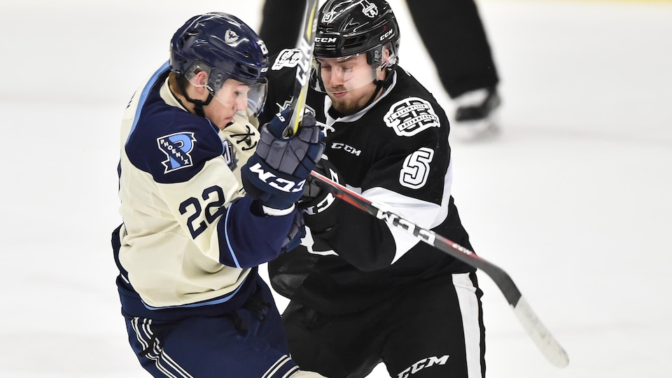 Deux joueurs de hockey d'équipes adverses entrent en collision.