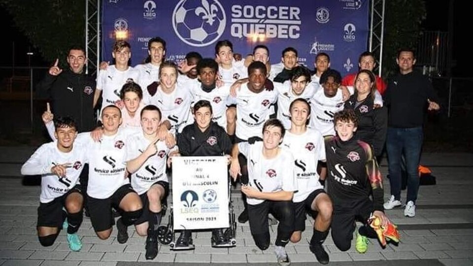 Des joueurs de soccer célèbrent avec leur bannière de champion.