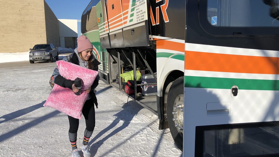 Une athlète monte à bord de l'autobus Intercar en partance pour Québec