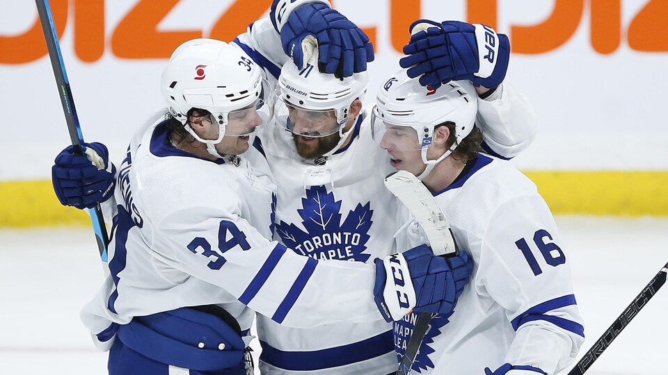 Auston Matthews, Nick Foligno et Mitch Marner célèbrent une victoire des Maple Leafs au son de la sirène.