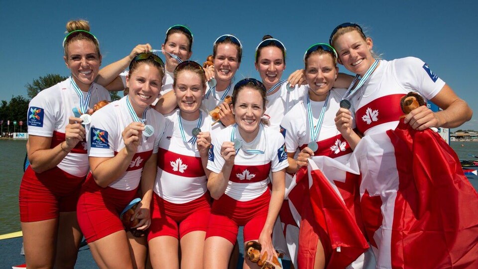 Les membres du huit canadien montrent leur médaille d'argent.