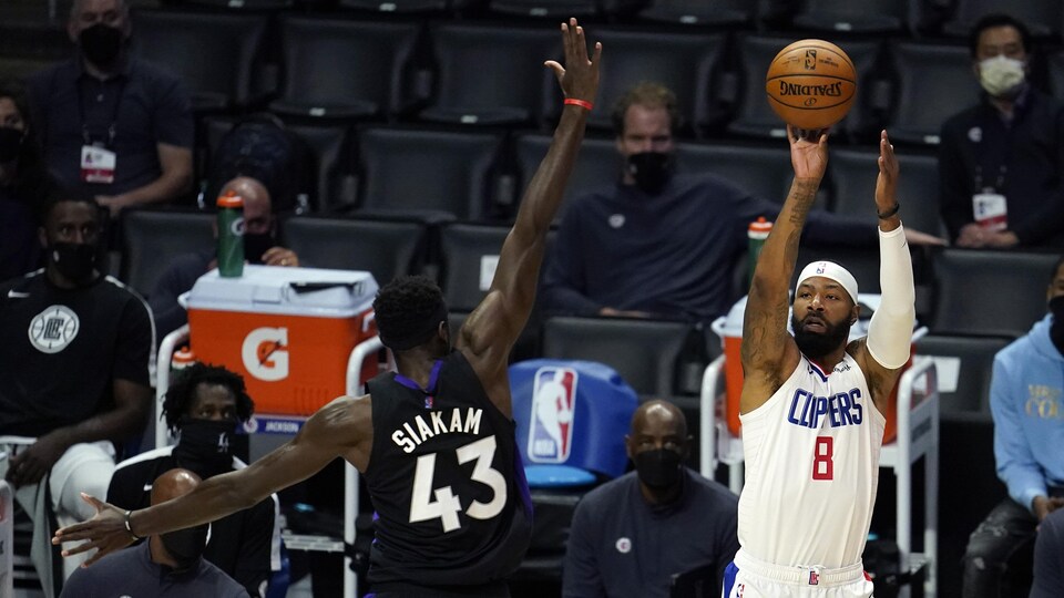 Il lance le ballon au moment où un adversaire torontois étend le bras devant lui.