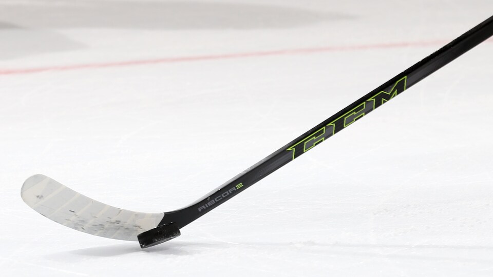 Un bâton de hockey noir CCM et une rondelle