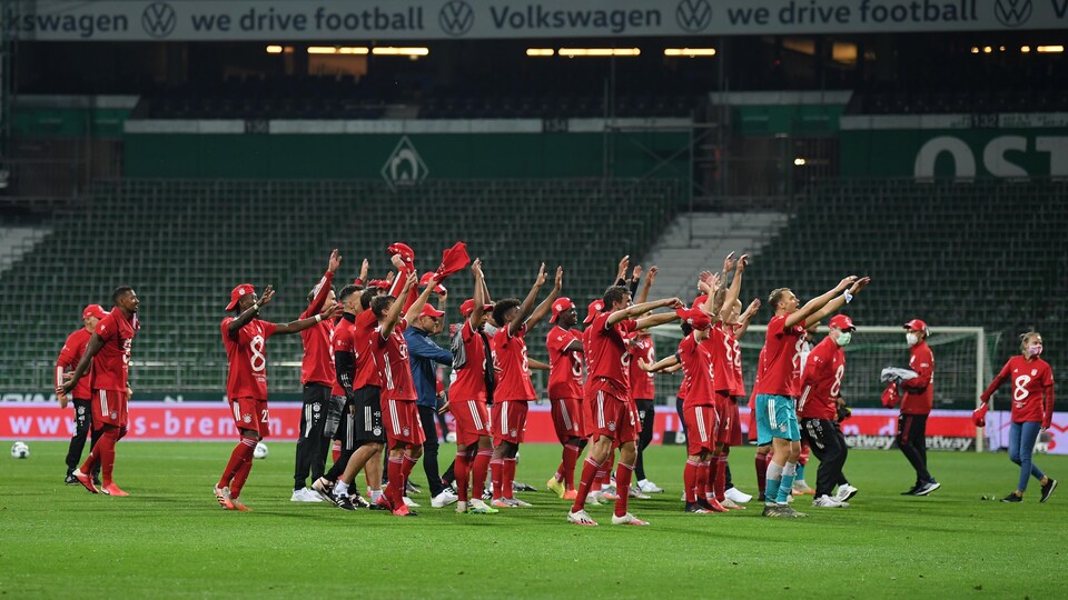 Ils fêtent dans un stade vide, sous la pluie.