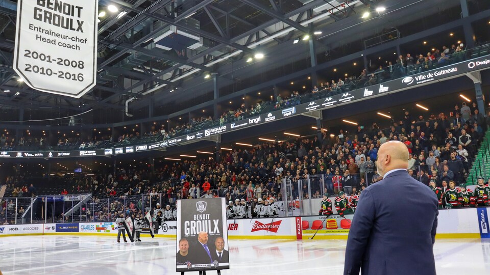Une foule regarde la fin d'une cérémonie dans un aréna.