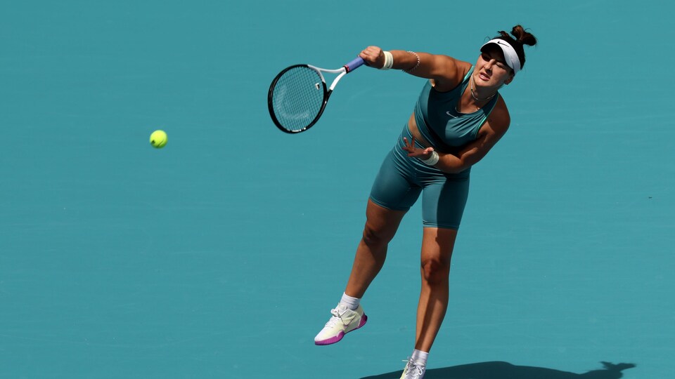 Une joueuse de tennis frappe une balle.