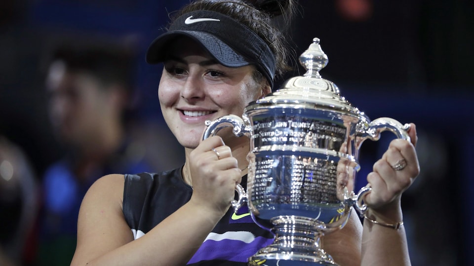 All smiles, she holds the champion's trophy in Flushing Meadows.