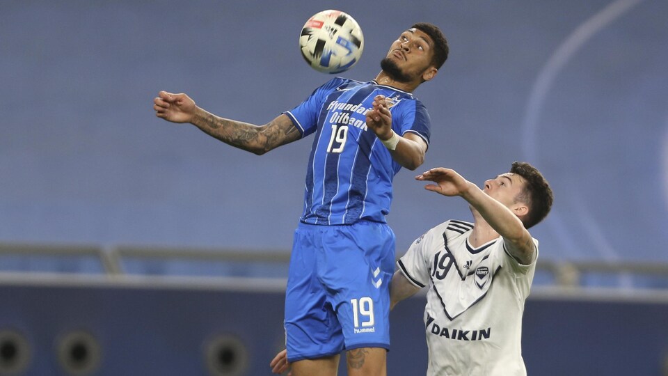 Bjorn Johnsen arrête le ballon de soccer de son torse devant Dylan Ryan.