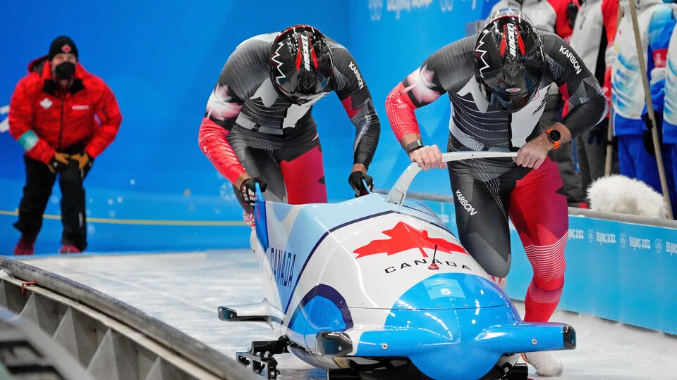 Two bobsledders set off at the start of the race.