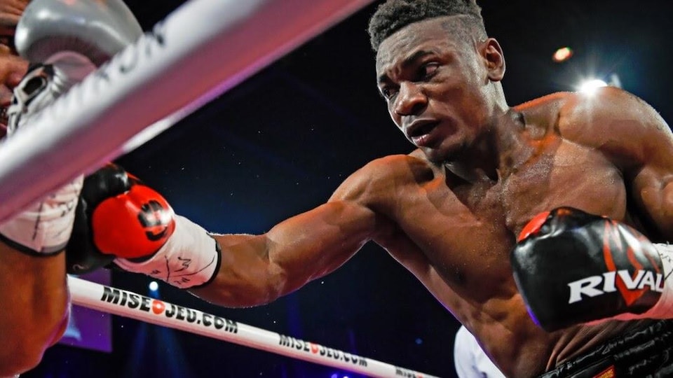 Il se jette sur son adversaire, coincé dans le coin du ring.