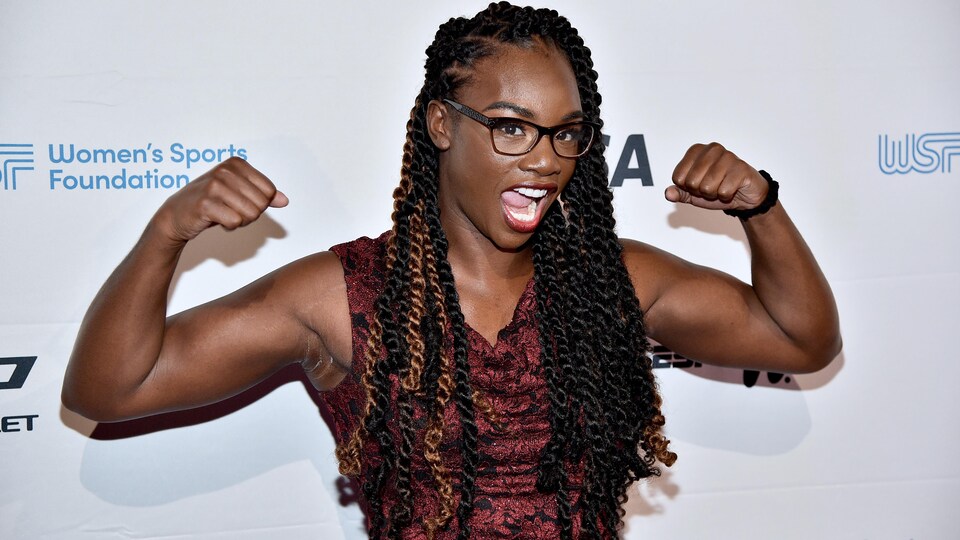 Elle montre ses biceps.
