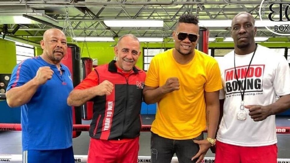 Quatre hommes dans un gymnase de boxe