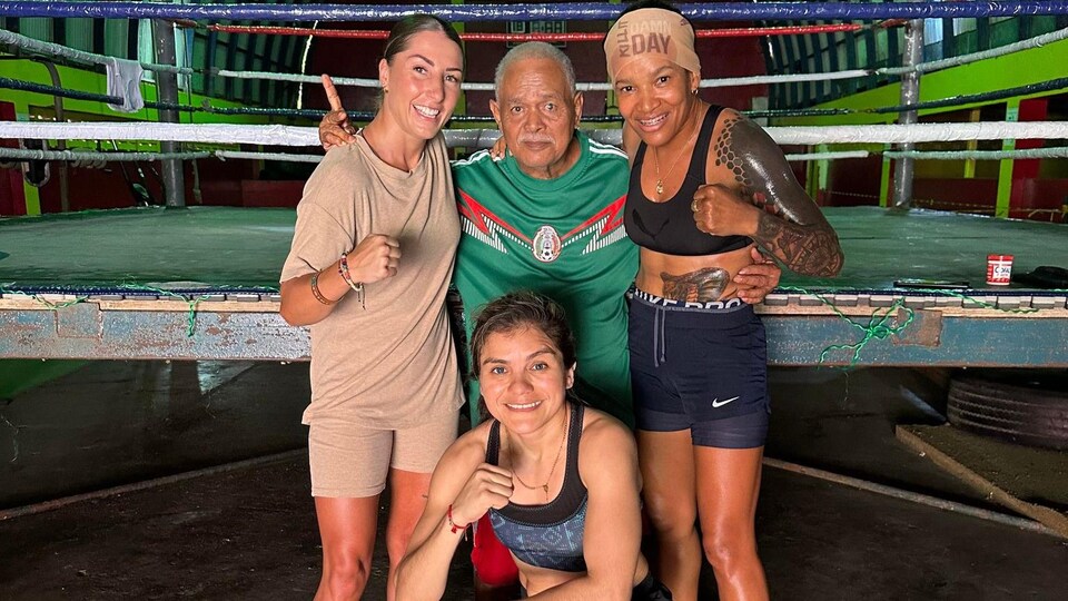 Quatre personnes, dont Kim Clavel et Olga Julio, prennent la pose près d'un ring de boxe.