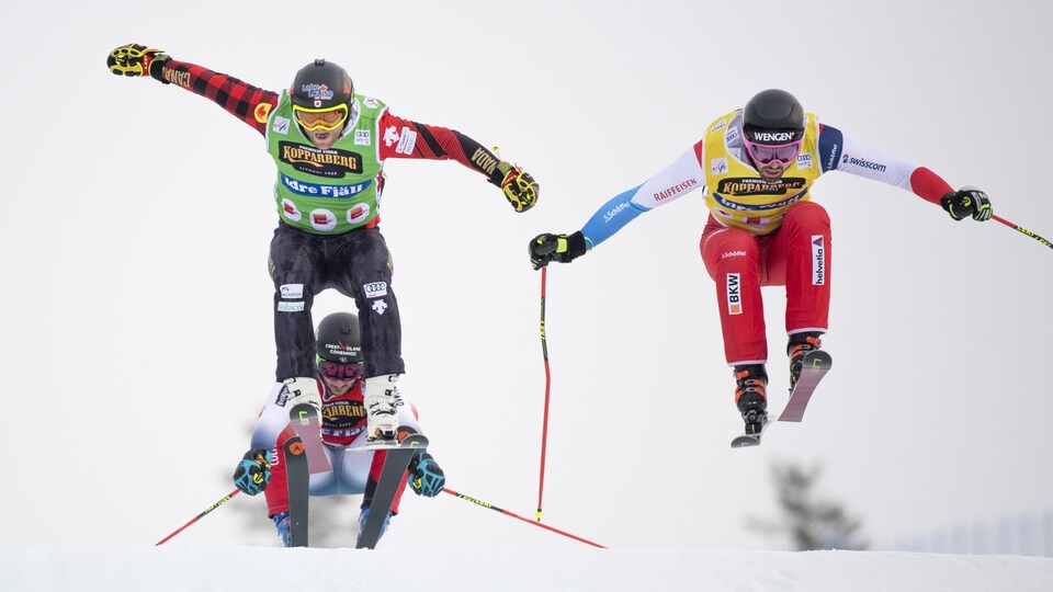 Deux skieurs s'envolent dans les airs.