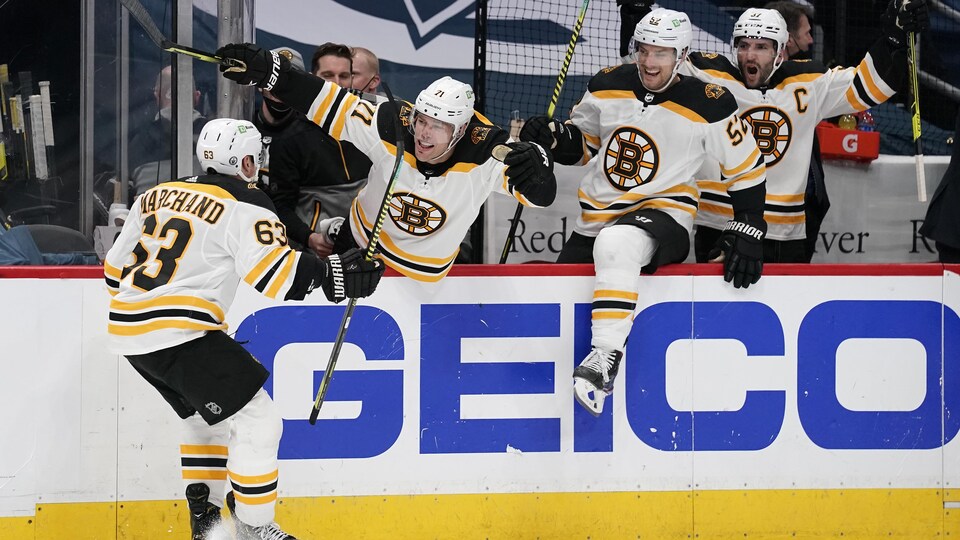 Les joueurs des Bruins de Boston célèbrent au banc le but de Brad Marchand.