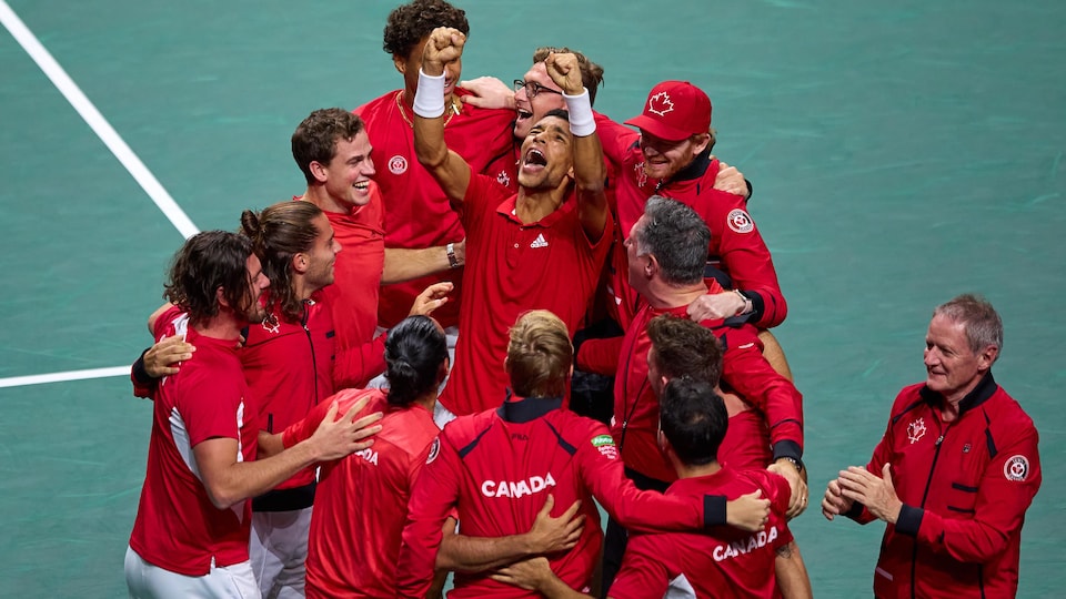 Des joueurs de tennis s'enlacent et célèbrent une victoire.