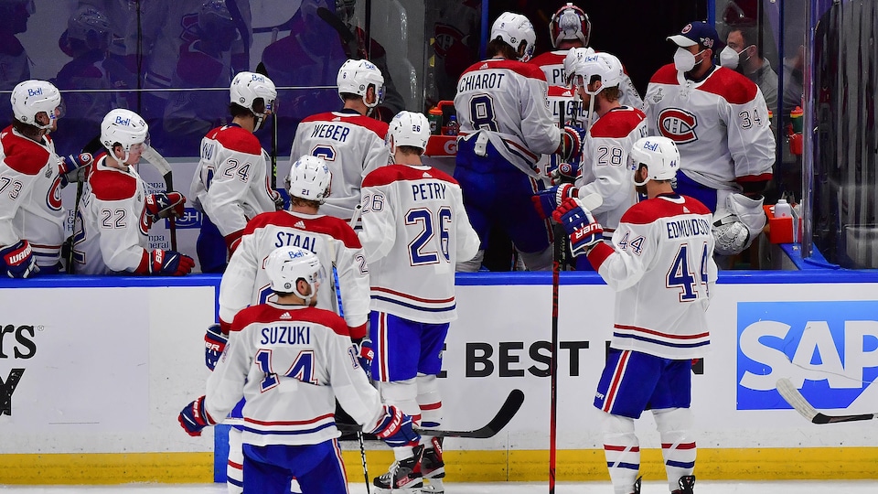 Des joueurs de hockey rentrent au vestiaire.
