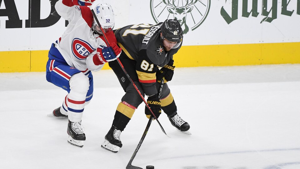 Deux joueurs de hockey bataillent pour l'obtention de la rondelle.