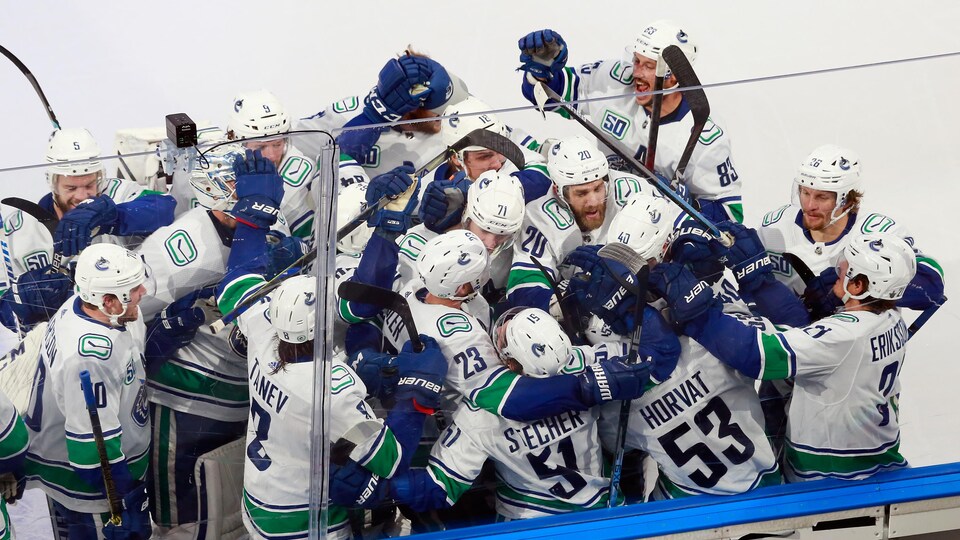 Les joueurs des Canucks qui se félicitent sur la glace.