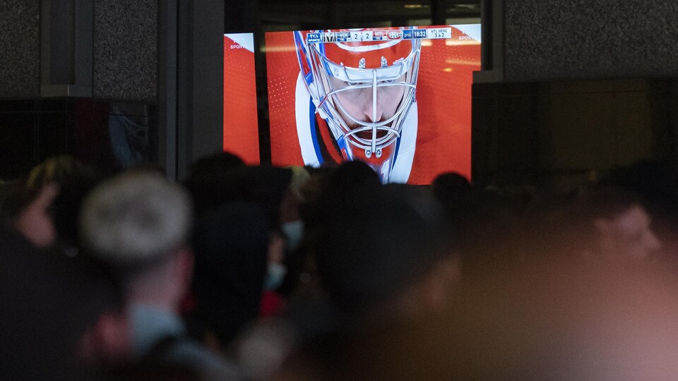 Des partisans regardent Carey Price sur un écran, à l'extérieur.