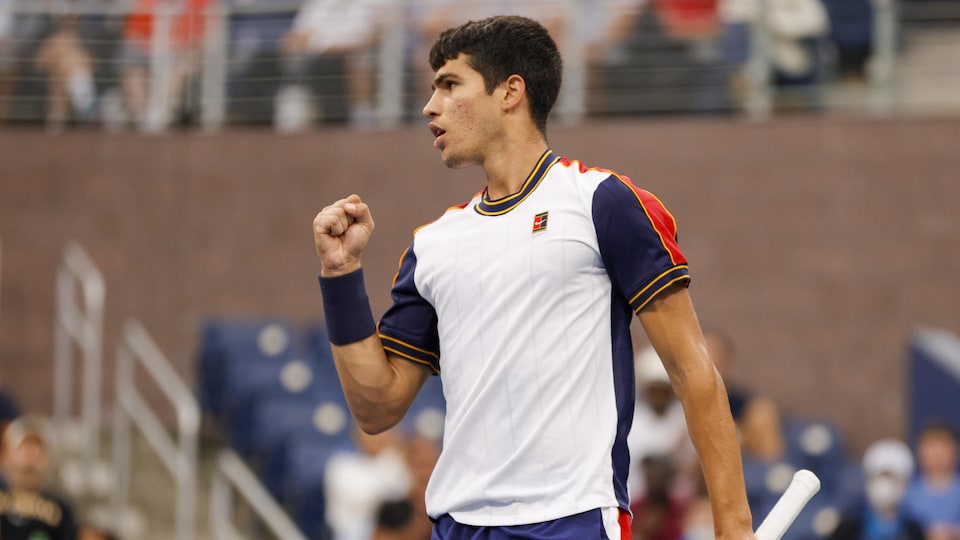 A tennis player serves with his right fist after scoring a point.