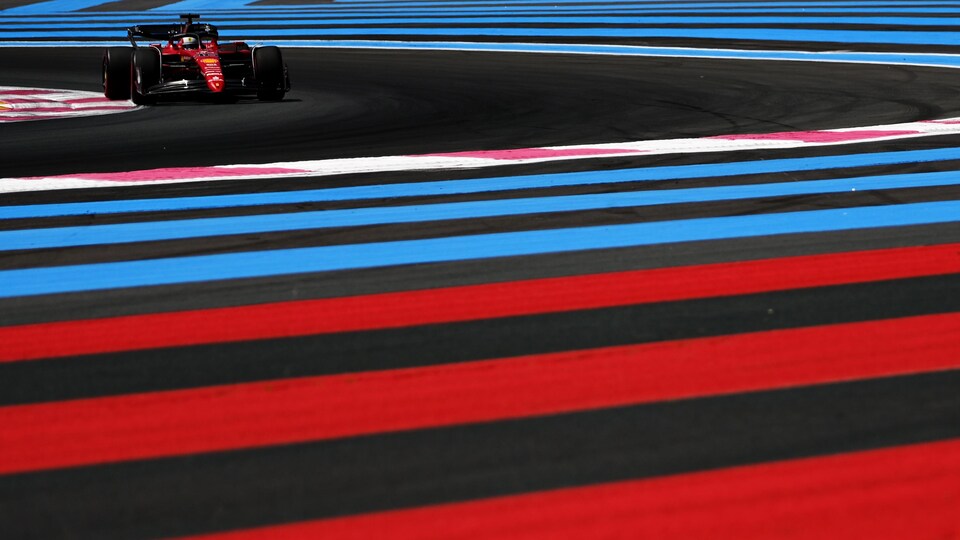 Un pilote de F1 dans une Ferrari négocie un virage à droite.