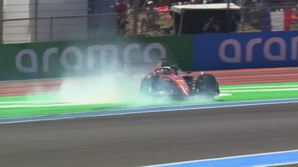 Une monoplace de F1 glisse de travers hors piste et les pneus bloqués font de la fumée.  